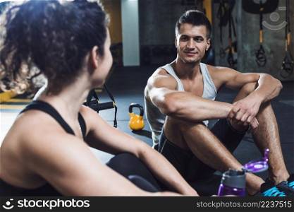 fit couple sitting floor gym