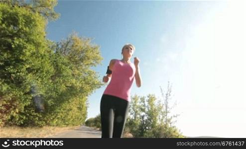 Fit female runner running on countryside road