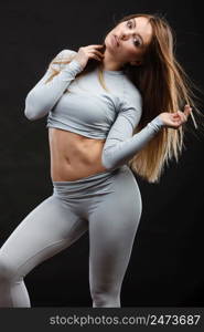 Fit fitness slim woman wearing hot gray sports thermolinen underwear, studio shot on black. Long sleeves top and leggings.. Fit woman in thermolinen underwear,