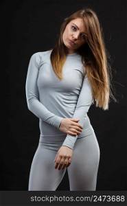 Fit fitness slim woman wearing hot gray sports thermolinen underwear, studio shot on black. Long sleeves top and leggings.. Fit woman in thermolinen underwear,