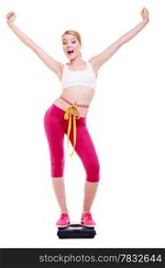 Fit fitness woman with measure tape happy blonde girl on weight scale celebrating weightloss progress after diet, she lost some weight. Healthy lifestyles concept