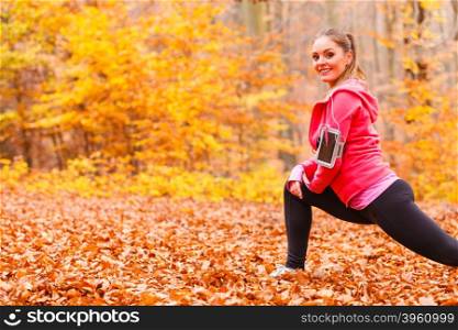 Fit girl doing stretching outdoor.. Stretching and exercising. Young sporty fit girl doing sports outdoor. Positive woman spending time on fresh air in autumnal forest.