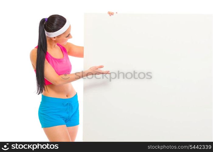 Fit girl in sportswear looking and pointing on blank billboard isolated on white&#xA;