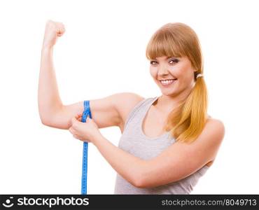 Fit girl with measure tape measuring her biceps. Power and energy. Health care and healthy active lifestyle. Young fitness woman fit girl with measure tape measuring her biceps on white