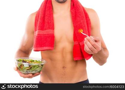 Fit man holding a bowl of fresh salad after a training day