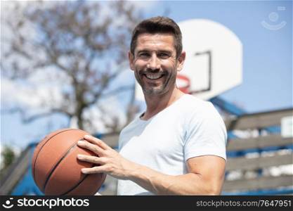 fit sportsman wearing t-shirt playing basketball isolated over white background