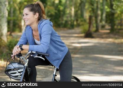 fit woman biking in forest