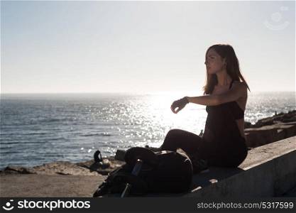 Fit woman enjoying the sunset after outdoor workout with weights