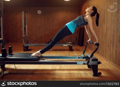 Fit woman in sportswear, pilates training on exercise machine in gym. Fitness workuot in sport club. Athletic female person, aerobics indoor. Fit woman, pilates training on exercise machine