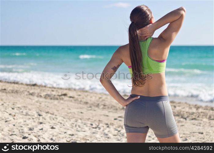 Fit woman relaxing after a run on the beach