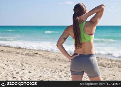 Fit woman relaxing after a run on the beach