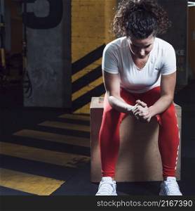 fit woman sitting wooden box gym