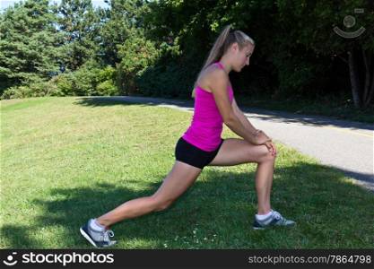 Fit woman stretching her muscles before running