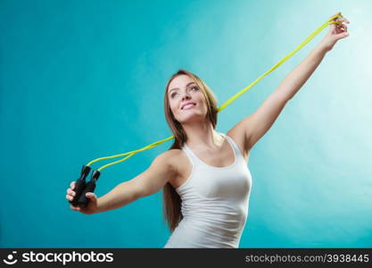 Fit woman with jumping rope. Young fit slim woman spend actively free time. Beauty happy girl wearing sports clothes with jumping skipping rope on blue background.