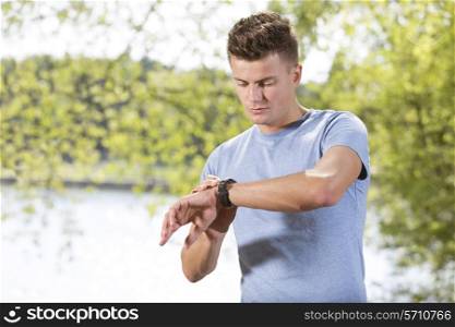 Fit young man checking time at park