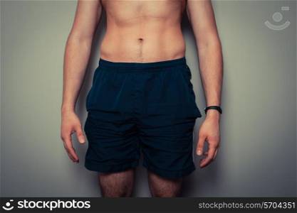 Fit young man with toned stomach standing in relaxed pose