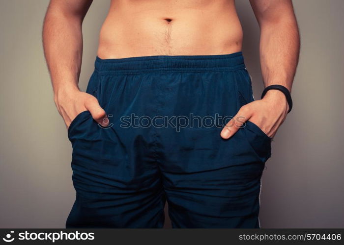 Fit young man with toned stomach standing in relaxed pose