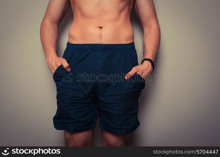 Fit young man with toned stomach standing in relaxed pose