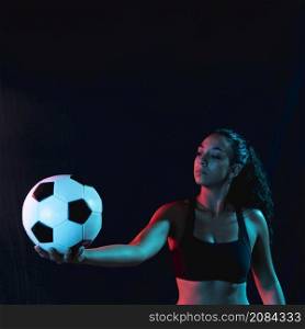 fit young woman holding soccer ball
