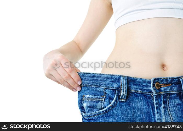 Fit young woman in loose jeans after losing weight isolated on white