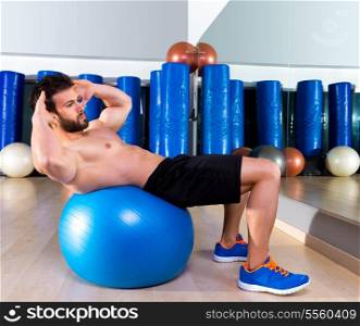 Fitball abdominal crunch Swiss ball man at fitness gym