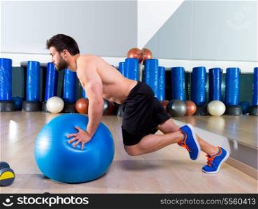 Fitball abdominal push ups Swiss ball man one single leg pushup at fitness gym