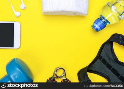 Fitness activity concept - flat lay of some personal sport accessories for woman on a yellow background with copy space.