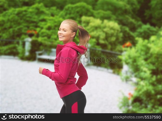 fitness and activity concept - beautiful sporty woman running or jumping