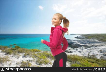 fitness and activity concept - beautiful sporty woman running or jumping