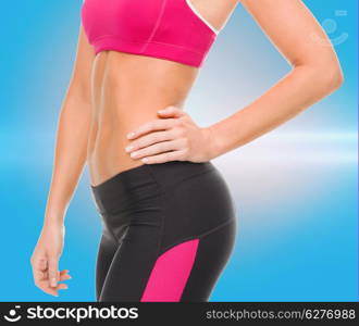 fitness and diet concept - close up of beautiful athletic female abs in sportswear