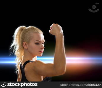 fitness and diet concept - close up of beautiful athletic woman flexing her biceps