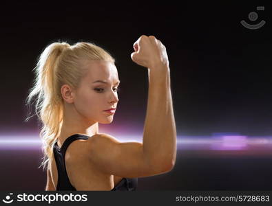 fitness and diet concept - close up of beautiful athletic woman flexing her biceps