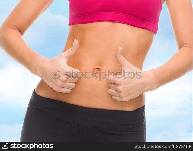 fitness and diet concept - close up of female abs and hands showing thumbs up