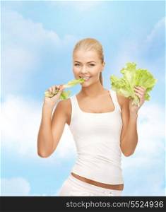 fitness and diet concept - healthy woman biting piece of lettuce