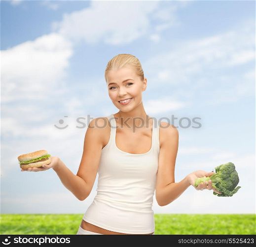 fitness and diet concept - picture of sporty woman with broccoli and hamburger