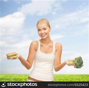 fitness and diet concept - picture of sporty woman with broccoli and hamburger