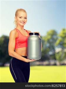 fitness and diet concept - smiling sporty woman with jar of protein. smiling sporty woman with jar of protein