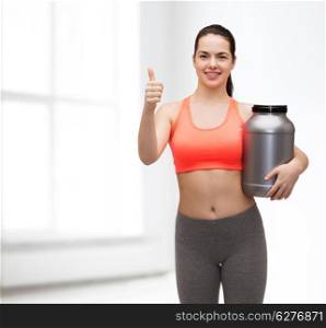 fitness and diet concept - smiling teenage girl with jar of protein showing thumbs up