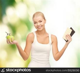 fitness and diet concept - sporty woman with apple and chocolate bars