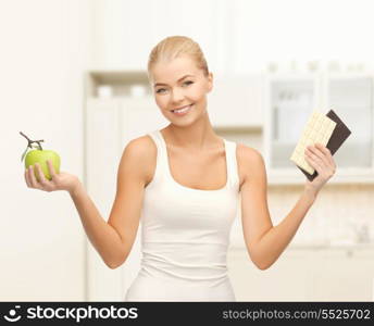 fitness and diet concept - sporty woman with apple and chocolate bars