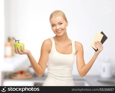 fitness and diet concept - sporty woman with apple and chocolate bars