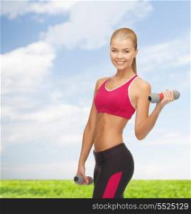 fitness and diet concept - young sporty woman with light dumbbells