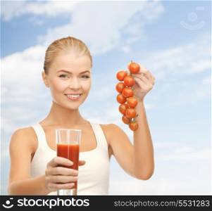 fitness and diet concept - young woman holding glass of juice and tomatoes