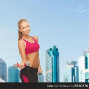 fitness and dite concept - young sporty woman with light dumbbells