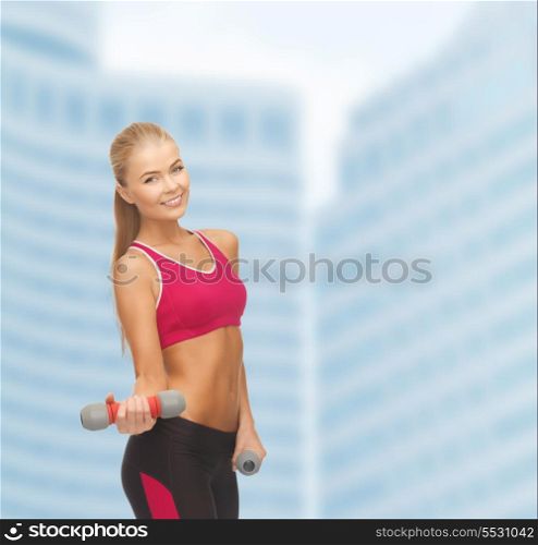 fitness and dite concept - young sporty woman with light dumbbells