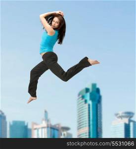 fitness and excercise concept - beautiful sporty woman jumping in sportswear