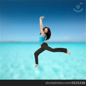 fitness and exercise concept - beautiful sporty woman jumping in sportswear