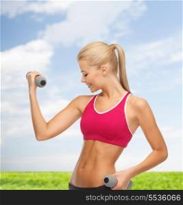 fitness and health concept - young sporty woman with light dumbbells outdoors
