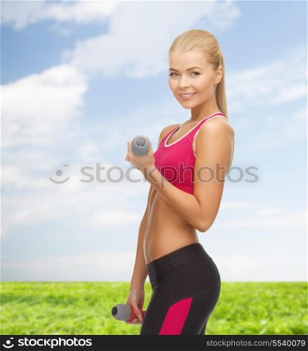 fitness and healthcare concept - young sporty woman with light dumbbells