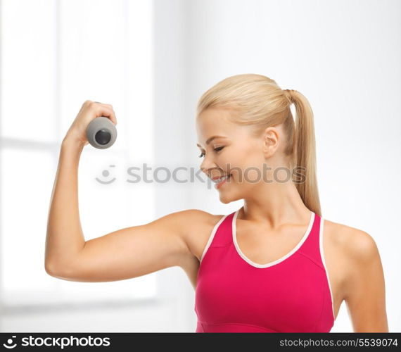 fitness and home concept - young sporty woman with light dumbbell